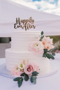 Wedding Cake decorated with Happily Ever After topper and blush flowers